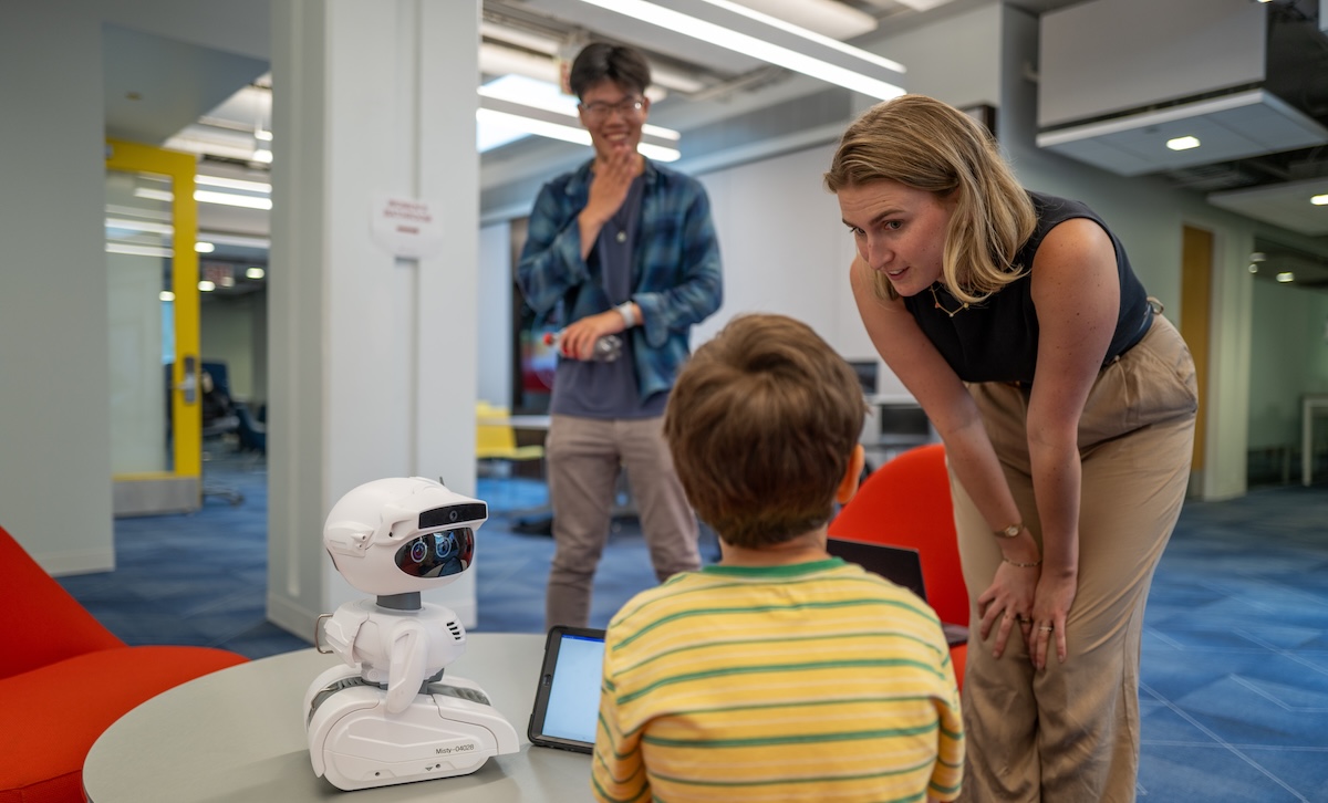 Adults and child engaging with a robot